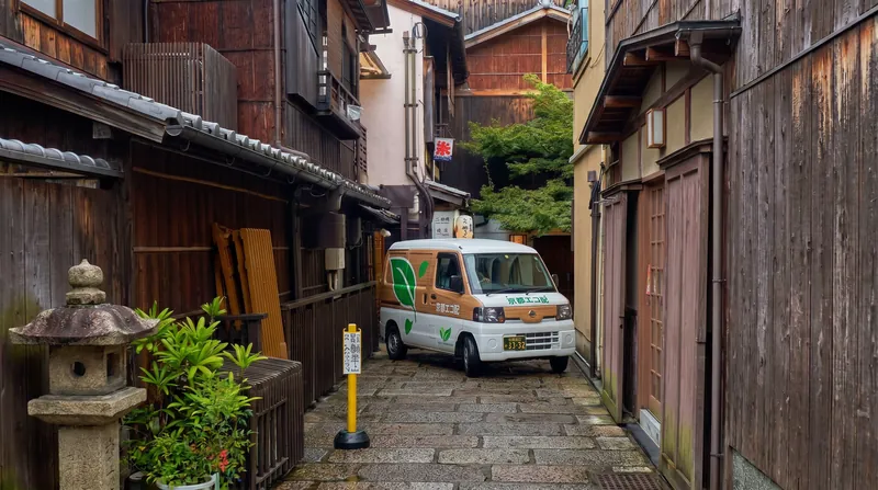 Small, eco-friendly delivery vans are utilized to navigate Kyoto's historic, narrow streets without causing congestion.