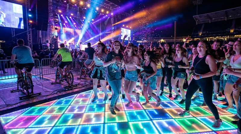 Kinetic dance floors and stationary power bikes allow fans to actively generate clean electricity for the stage.