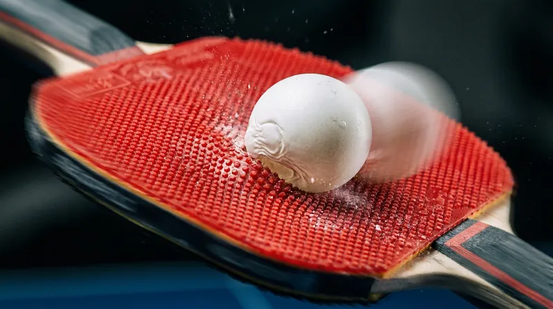 Modern high-tension rubbers provide the necessary grip to execute the stroke against the heavier plastic ball.