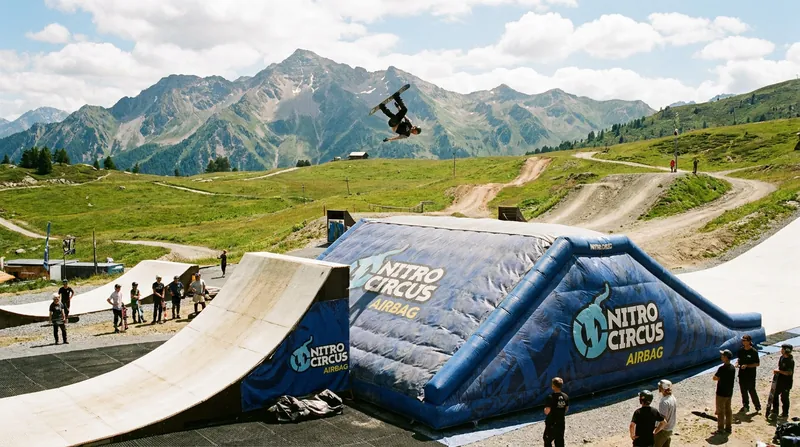 Sloped airbag facilities allow athletes to attempt high-consequence tricks dozens of times a day without the risk of hard-snow impacts.
