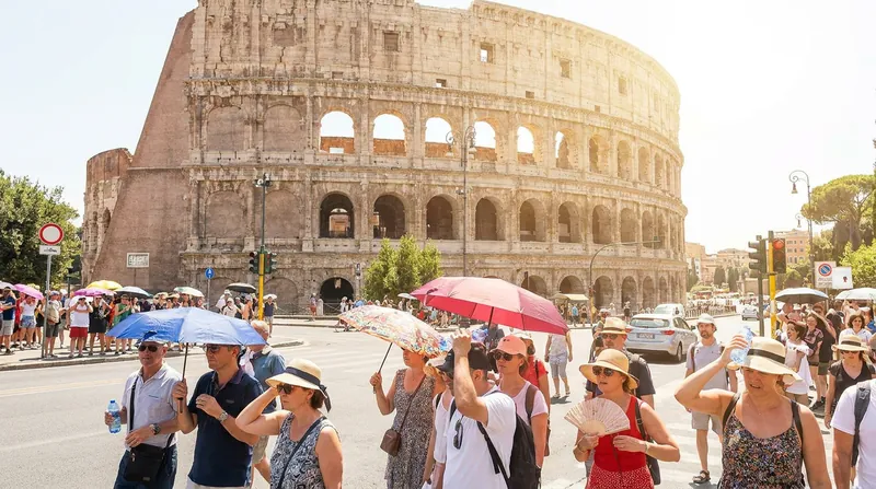 Tourists attempt to shield themselves from the sun in Rome, one of 16 Italian cities under a maximum red alert.