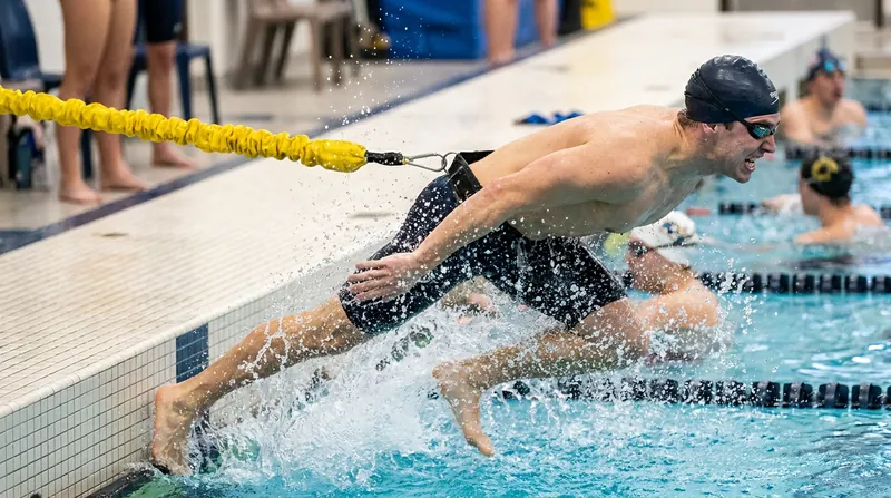 Elastic tethers provide progressive resistance, forcing the swimmer to accelerate aggressively through the end of the stroke.