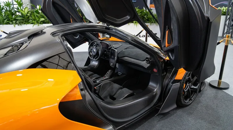 The W1 introduces anhedral gull-wing doors, which improve aerodynamic airflow over the front fenders compared to traditional butterfly doors.