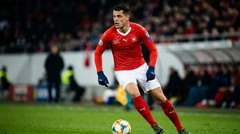 Granit Xhaka acts as the on-field orchestrator, frequently dropping into the defensive line to dictate the tempo.