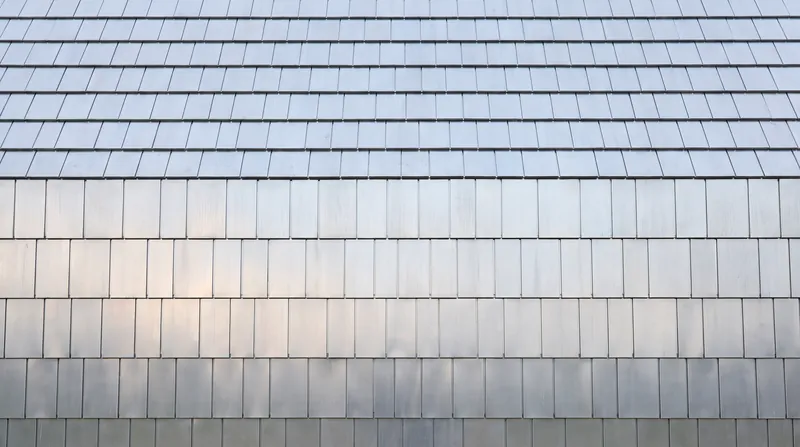 Marine aluminum cladding mimics traditional wooden shingles while reflecting the changing light of the seasons.