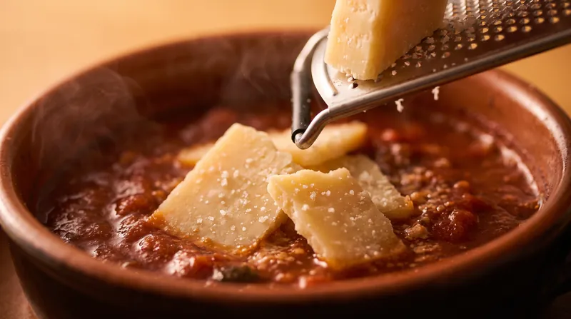 Aging cheese and slow-cooking tomatoes naturally breaks down proteins into free glutamate, maximizing their savory impact.