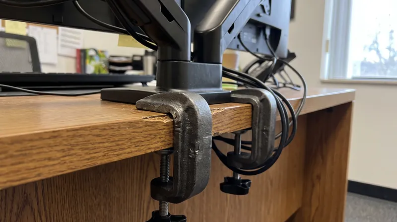 Monitor arms act as levers, requiring the desk core to possess high density to prevent crushing at the clamp point.