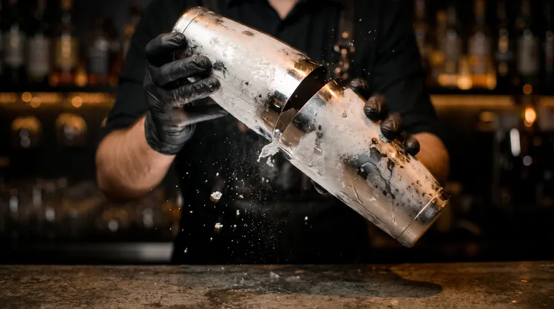 Shaking a cocktail forces the ice to melt rapidly, absorbing heat from the liquid until it reaches thermal equilibrium.