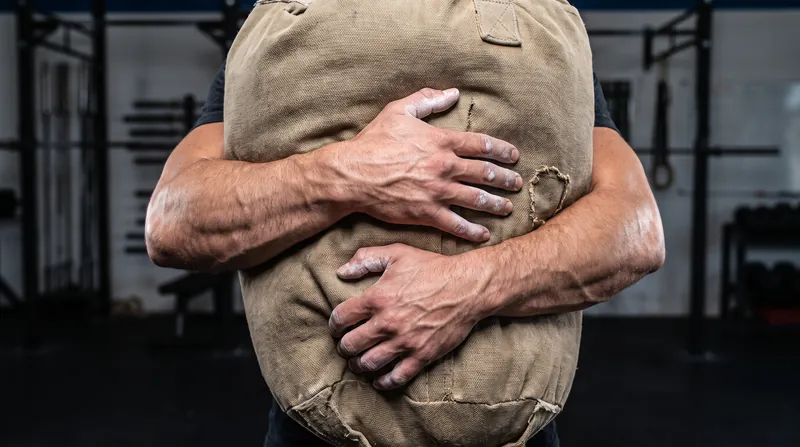 Bear-hugging a heavy load forces the thoracic spine and core into a near-maximal isometric contraction.