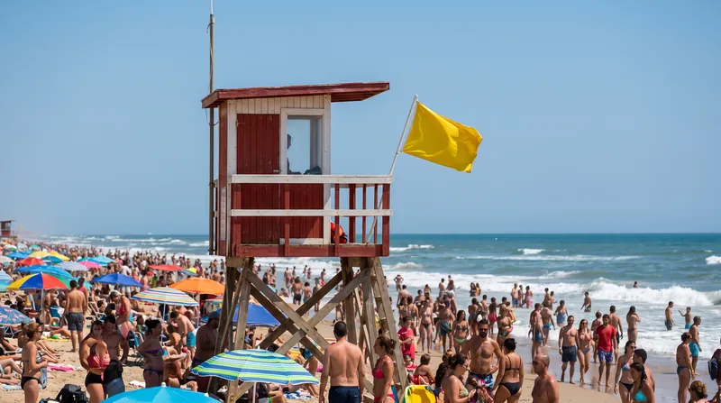 A yellow flag warns beachgoers of moderate hazards like strong currents or tricky surf.