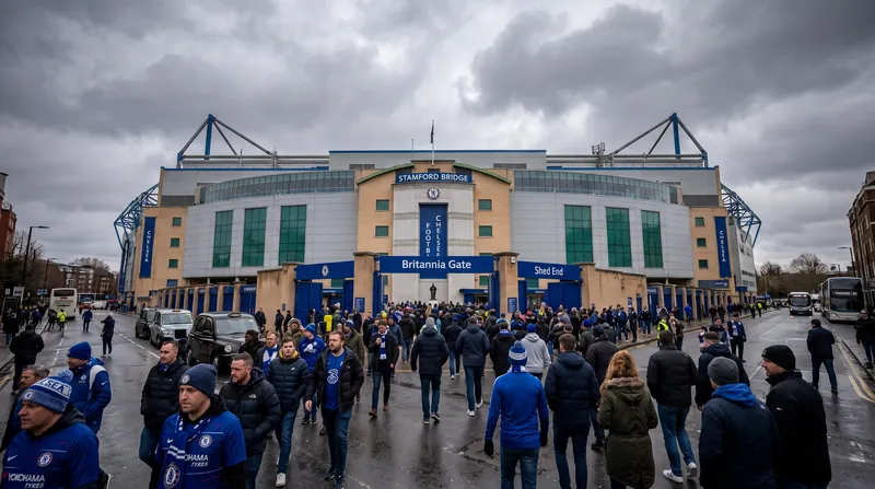 Exterior view of Stamford Bridge stadium in London with fans walking towards the entrance gates.