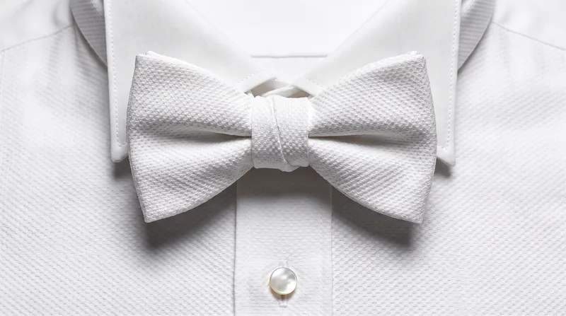 The white bow tie must be self-tied and made of cotton marcella, never silk.