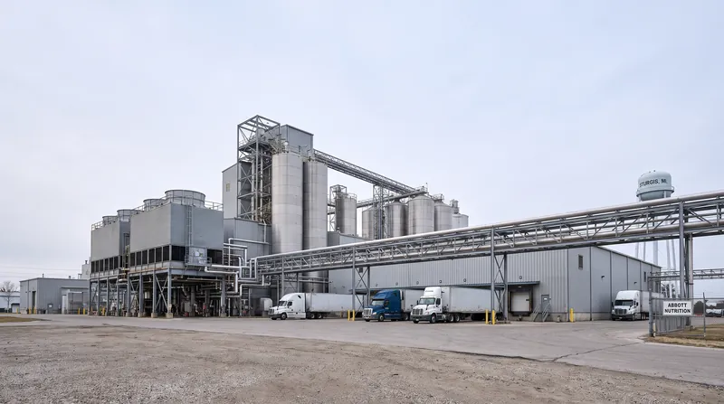 Exterior view of the large Abbott Laboratories manufacturing plant in Sturgis, Michigan, featuring industrial silos and piping.