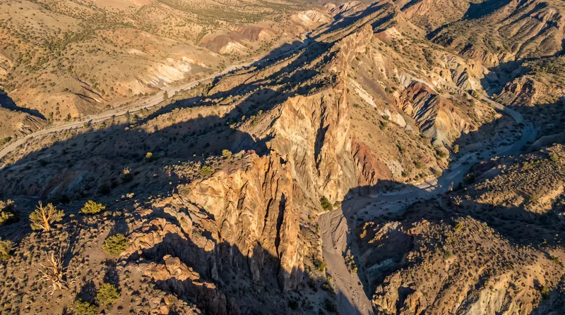 An aerial view of a large geological fault line cutting through a rugged, mountainous landscape.