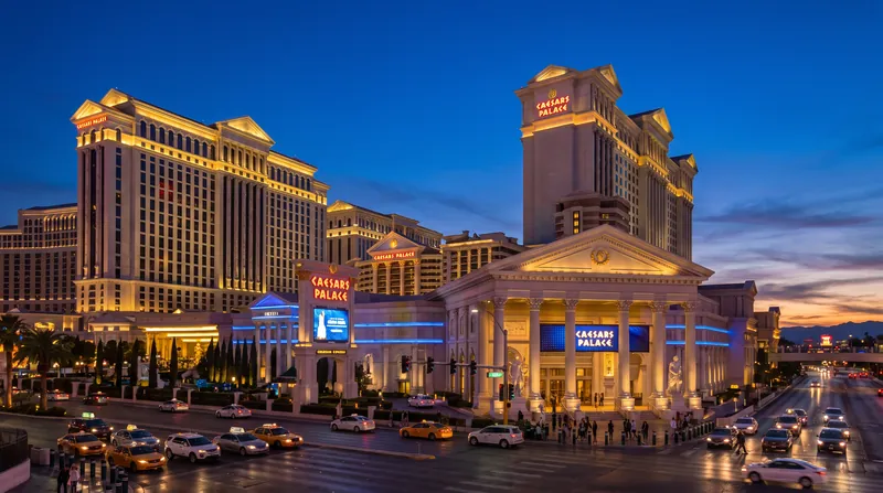 Exterior view of Caesars Palace casino and hotel on the Las Vegas Strip illuminated at dusk.