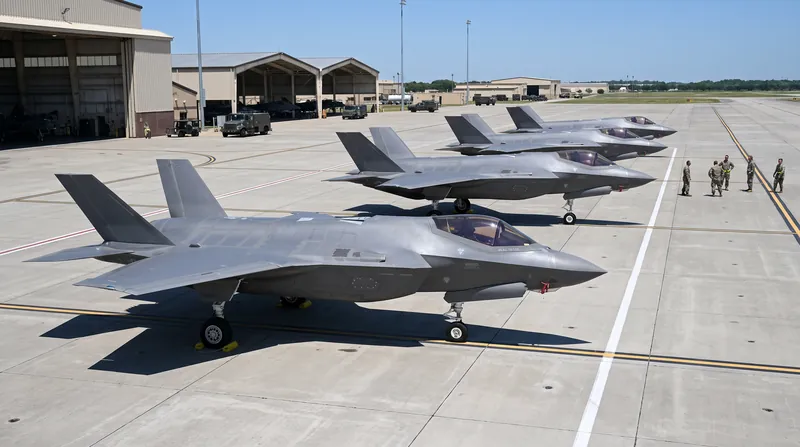 A row of F-35 Lightning II stealth fighter jets parked on a military flight line.