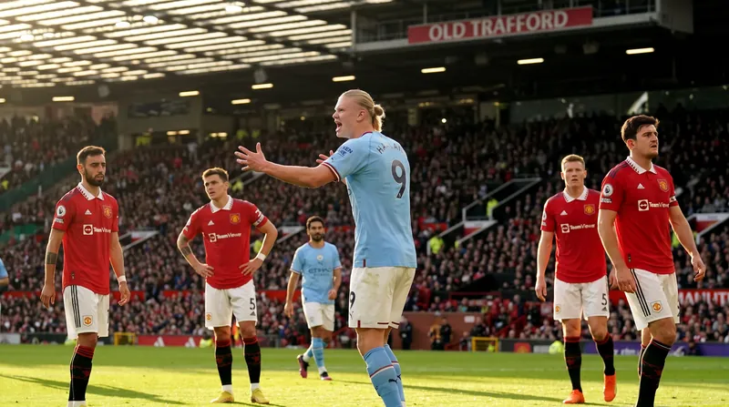 Erling Haaland in a light blue Manchester City jersey celebrates a goal on the pitch.
