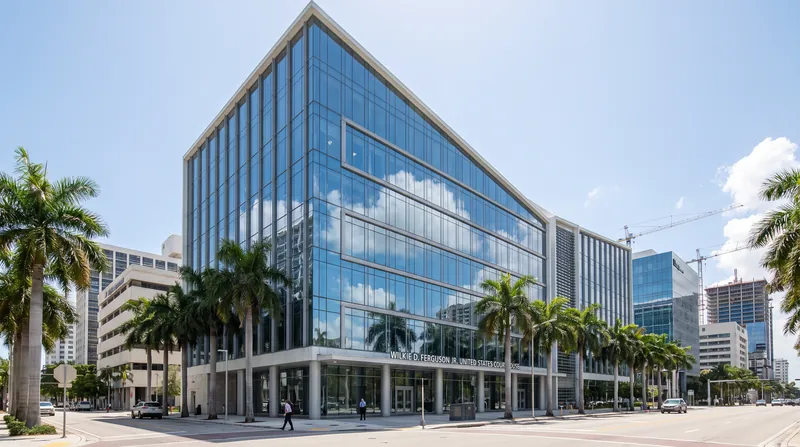 A wide exterior view of the modern glass facade of the federal courthouse in Miami.
