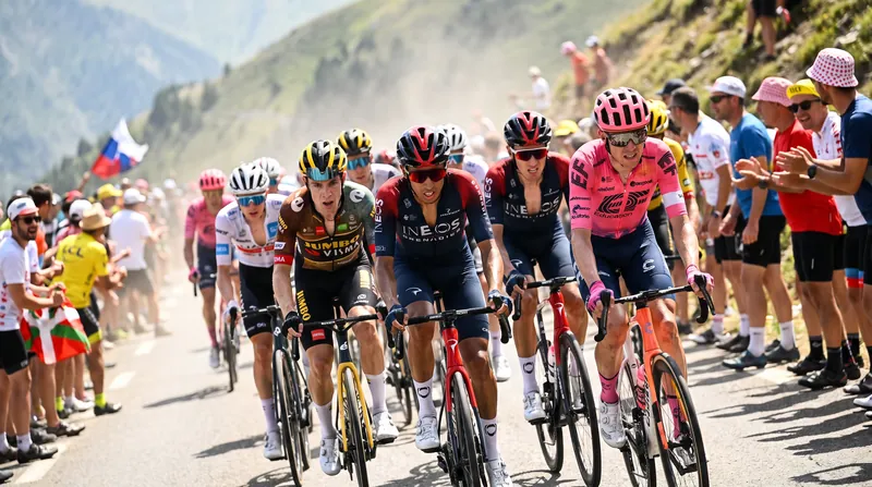 A large group of professional cyclists riding closely together up a steep mountain road during a race.