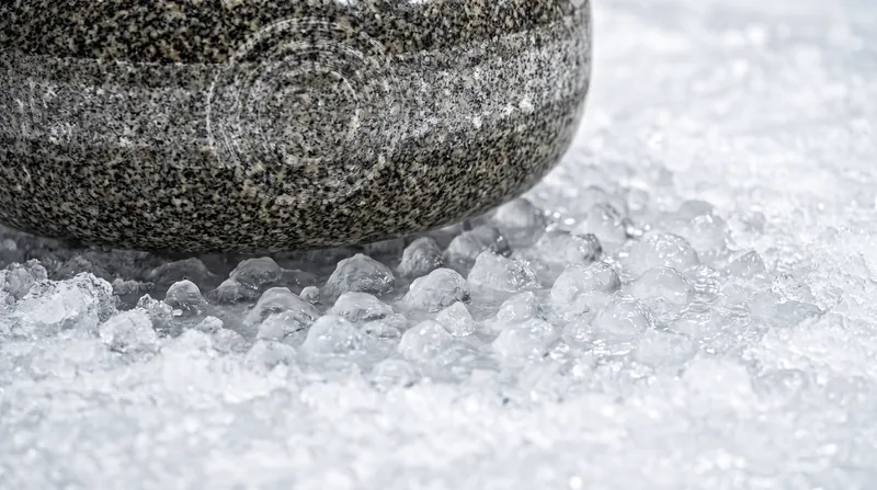 The stone rides exclusively on the peaks of the ice pebble, minimizing the contact area.