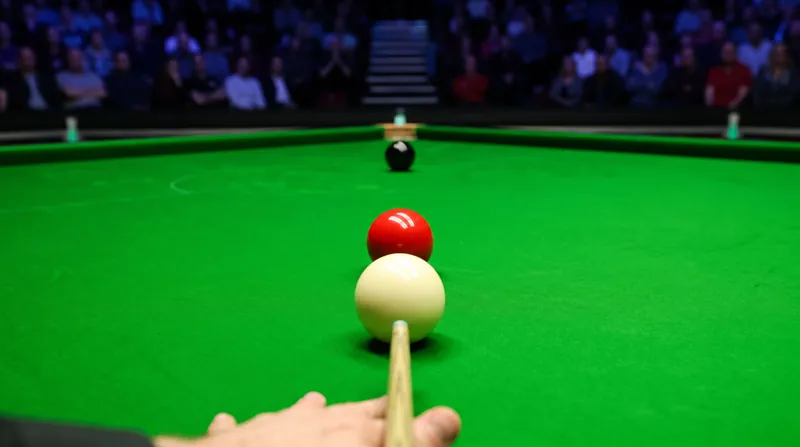 A professional snooker table showing a cue ball lined up with a red ball and the black ball nearby.