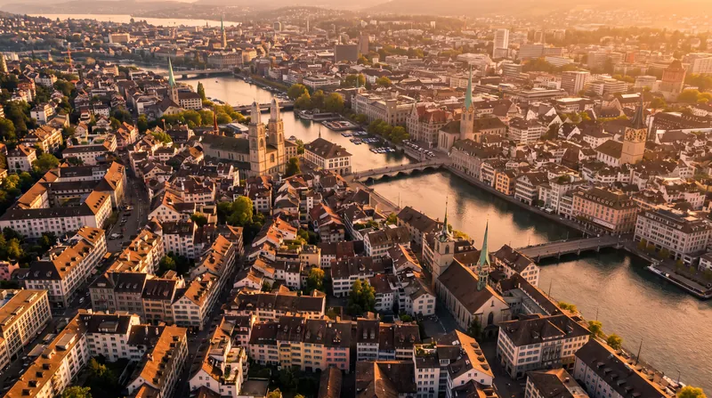 Aerial view of residential buildings and the skyline of Zurich, Switzerland, under a clear sky.