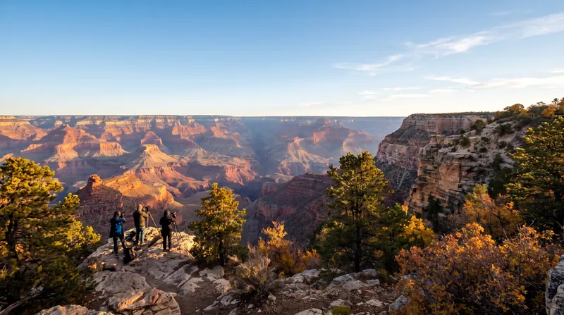 A view of the Grand Canyon's South Rim at sunrise, with layered rock formations under a clear sky.
