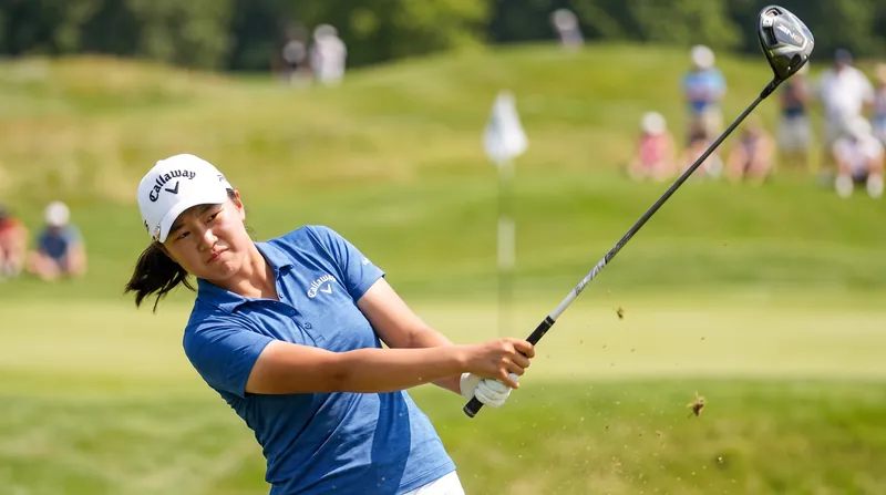 18-year-old golfer Yanhan Zhou standing on a golf course wearing a Callaway hat and holding a driver.
