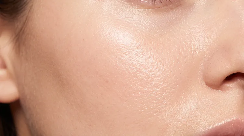 Macro photography of smooth, hydrated human skin texture under soft lighting.