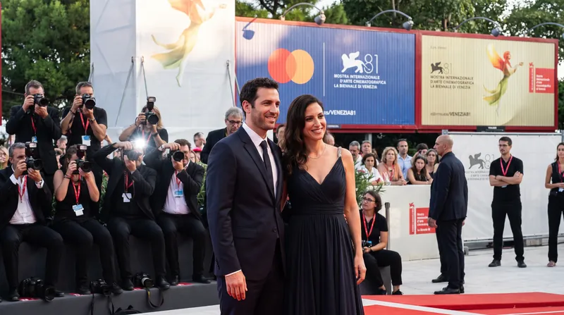 Documentary filmmakers Yuval Abraham and Rachel Szor standing together on the red carpet at the Venice Film Festival.