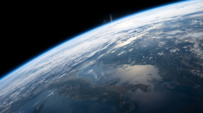A view of the Earth's curvature showing the thin blue atmospheric layer fading into black space.