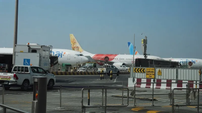 A Flydubai Boeing 737 aircraft parked on the tarmac at an active international airport.