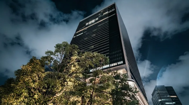 The modern glass facade of the SoftBank headquarters building in Tokyo on a sunny day.