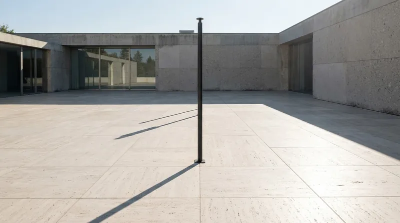 A printed map and a transparent protractor resting on concrete next to a sharp shadow cast by a streetlamp.