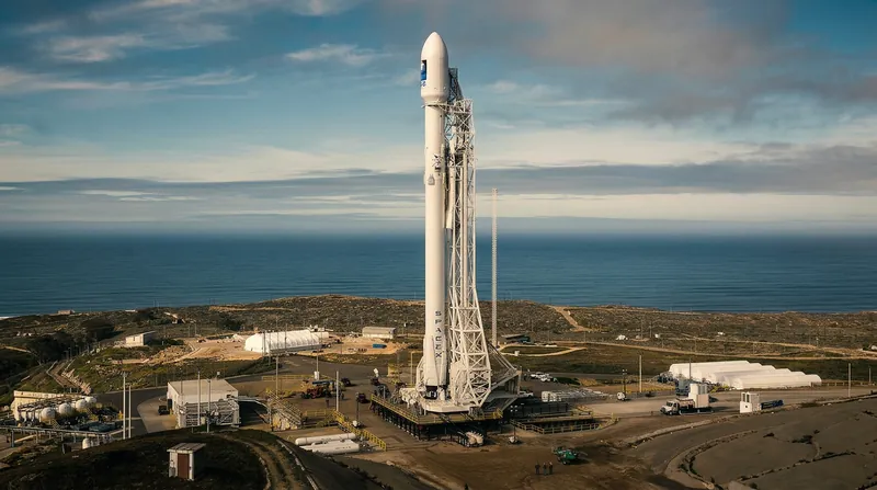 A large orbital rocket ascends through a clear blue sky, leaving a bright exhaust plume.