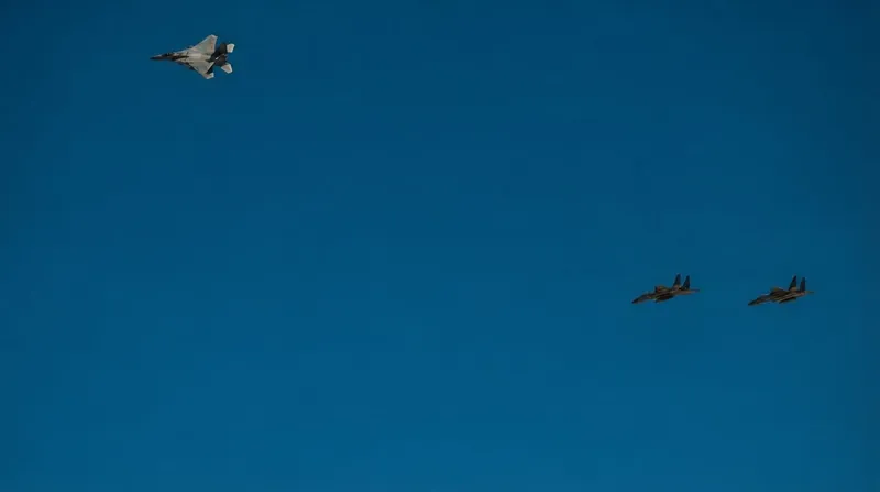 A Saudi Royal Air Force F-15 fighter jet takes off from a desert airbase at dusk.