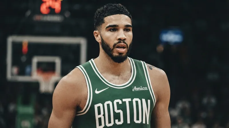 Boston Celtics forward Jayson Tatum stands on the basketball court in his green uniform, looking focused.