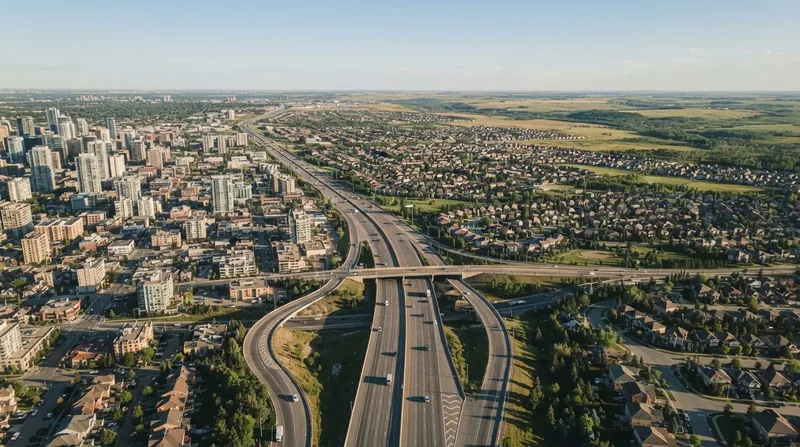 Aerial view of a large, complex highway interchange surrounded by sprawling suburban housing developments.