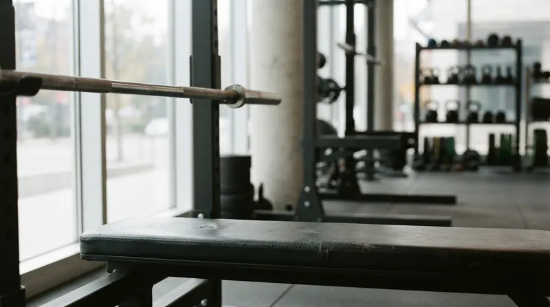 A powerlifter holding a heavy barbell at the bottom of a bench press, with the bar touching their chest.