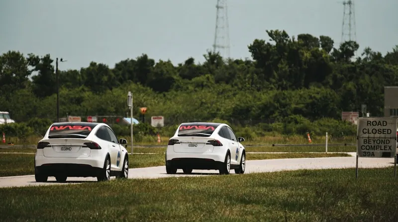 Exterior view of a modern corporate building displaying both the Tesla and SpaceX logos.