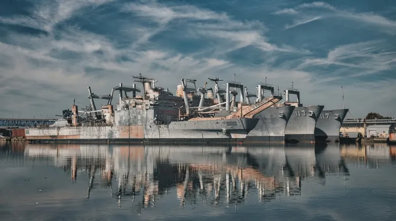 A United States Navy littoral combat ship sailing through open ocean waters under bright daylight.