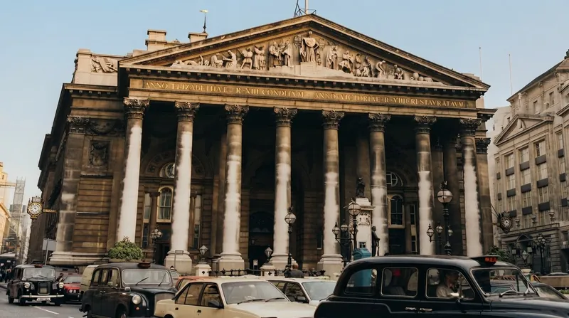 The classical stone facade of the Bank of England building in London under an overcast sky.