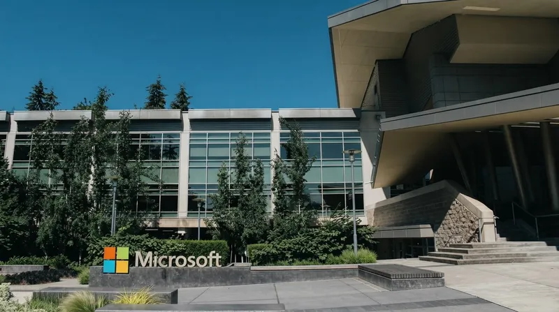 Exterior view of a modern Microsoft Xbox corporate office building with glass architecture and subtle green accents.