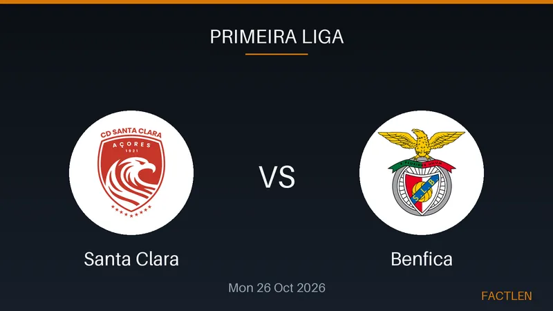 A Benfica soccer player in a red jersey celebrates a goal on a wet pitch under stadium lights.