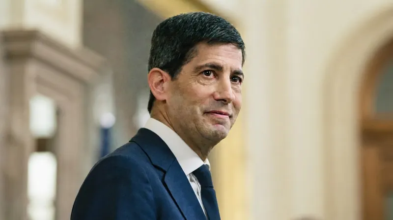 Federal Reserve Chairman Kevin Warsh speaking at a podium in a formal institutional setting.